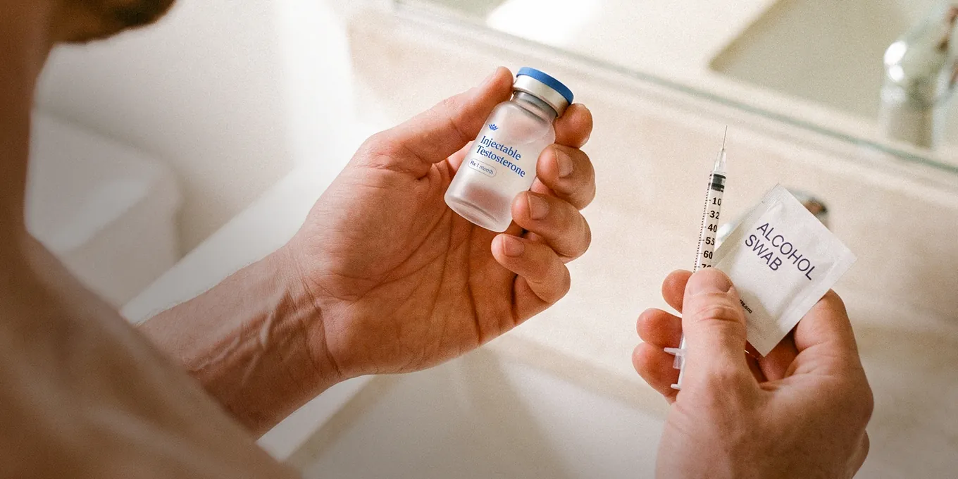 Injectable testosterone vial, syringe and alcohol swab held in two hands